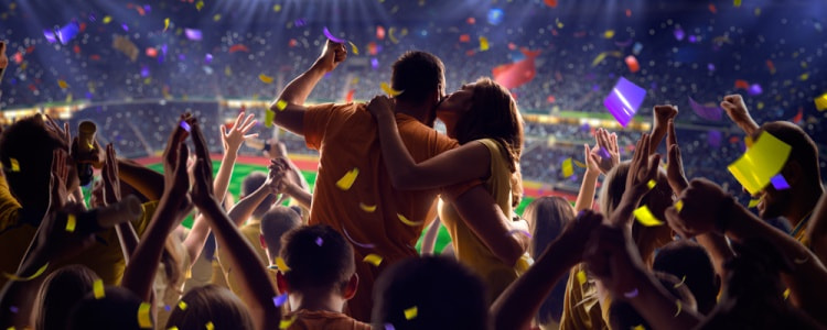 Sports fans cheering at a stadium at night